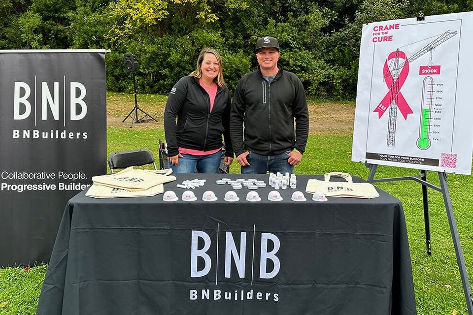 Two people at a booth fundraising for Crane for the Cure.