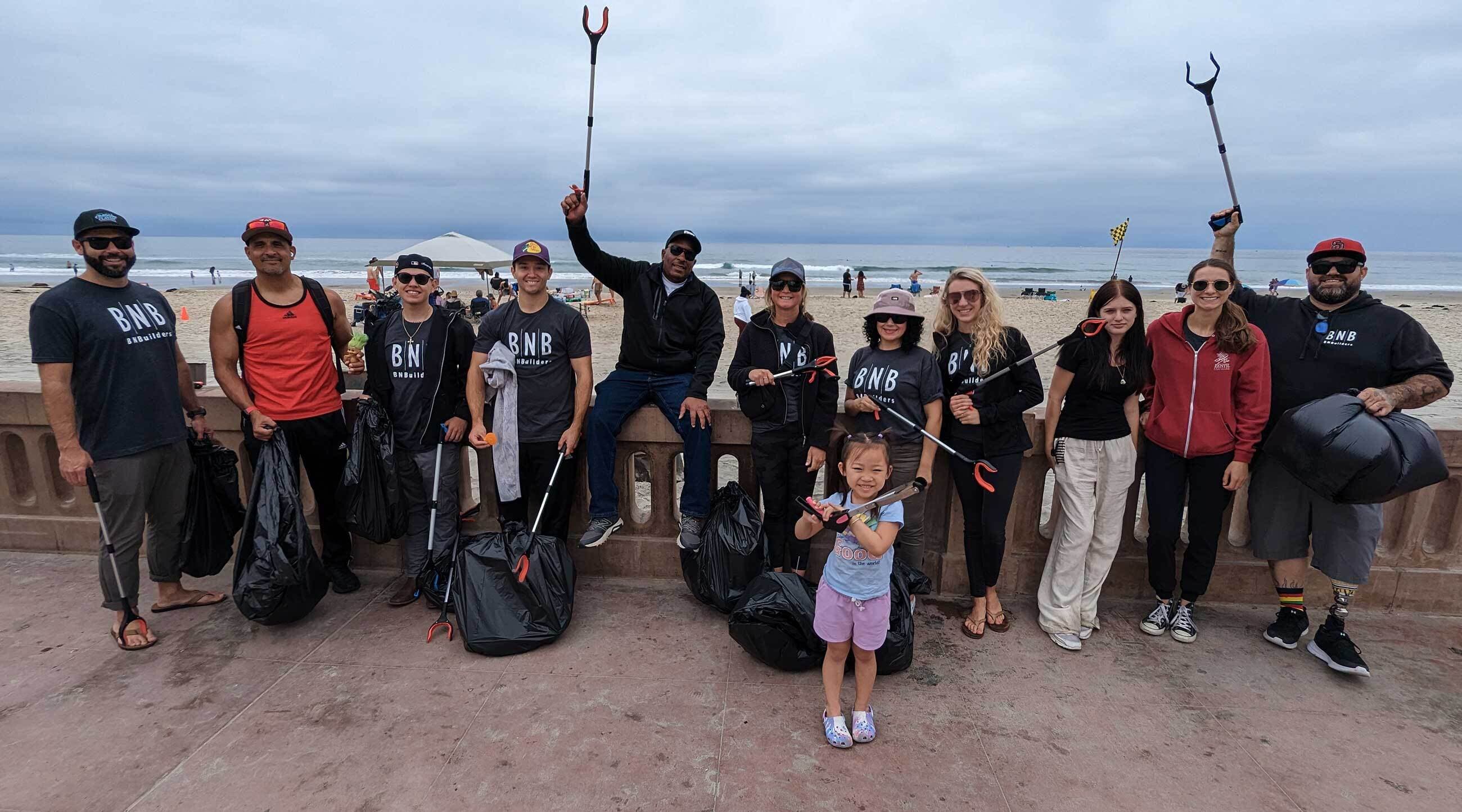 Group of people cleaning up trash on a beach.