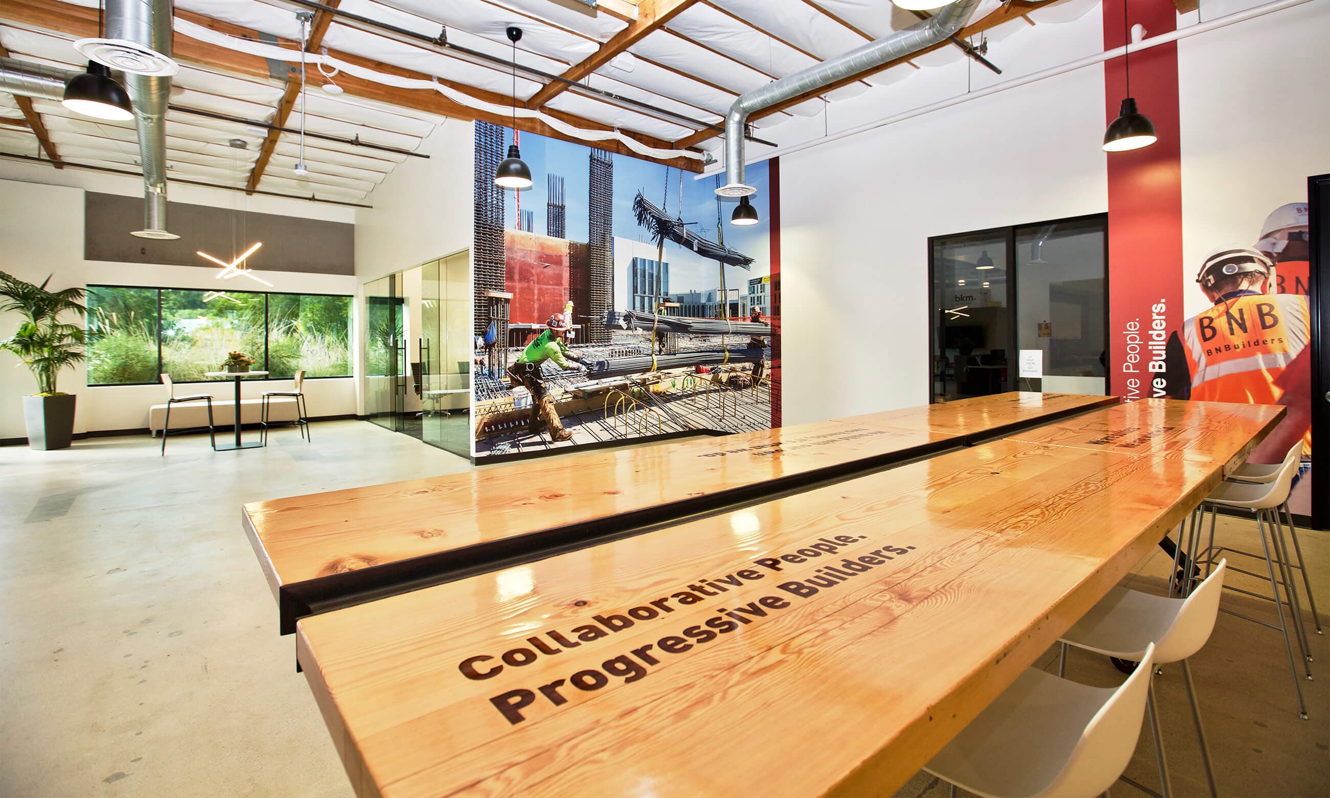 Meeting table engraved with the slogan "Collaborative People. Progressive Builders."