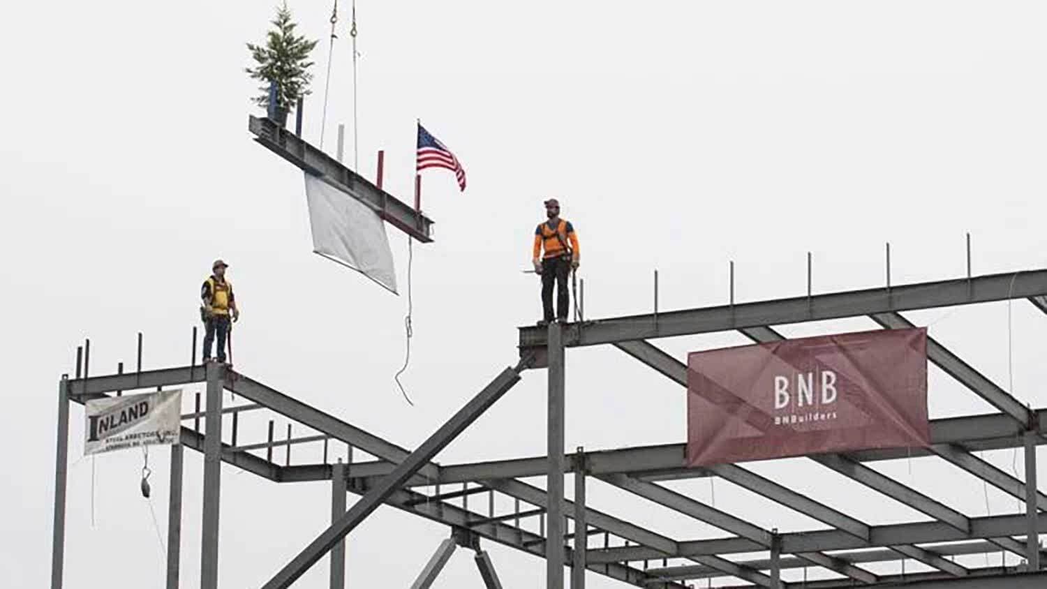 Construction crew hoisting the final steel beam into place atop Skagit Regional Health's new building.