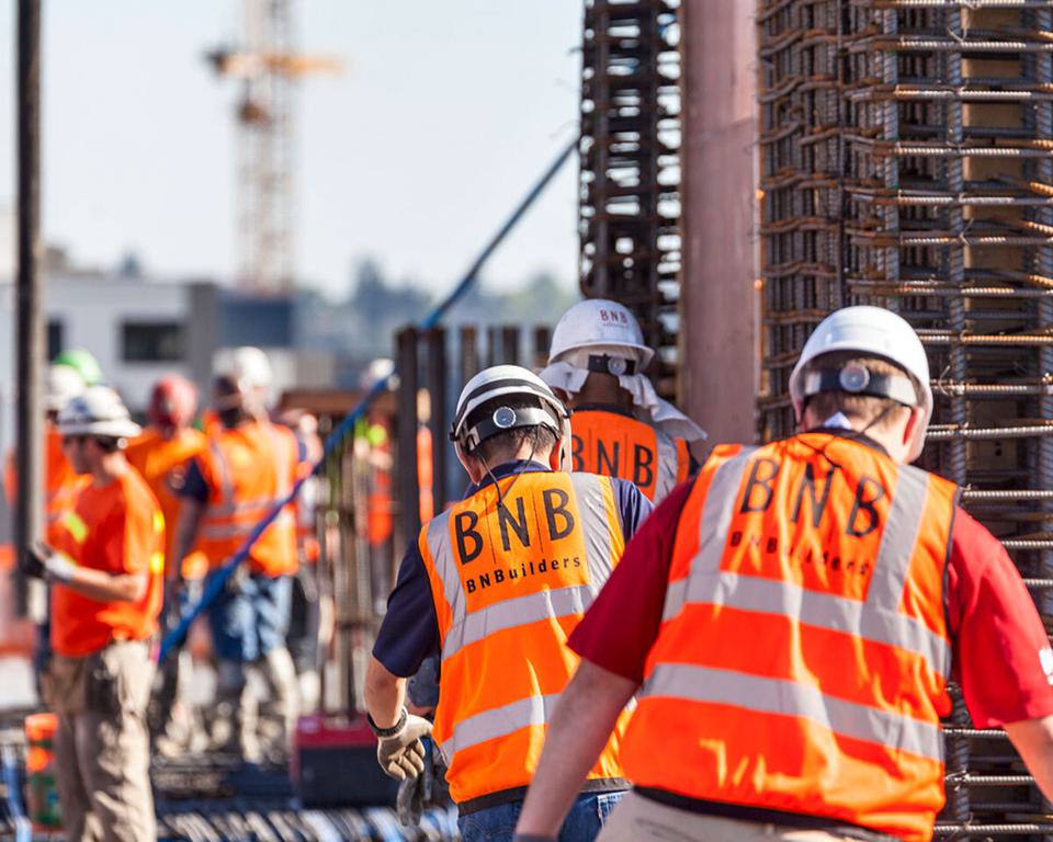 Construction workers on the job with BNBuilders safety vests on.